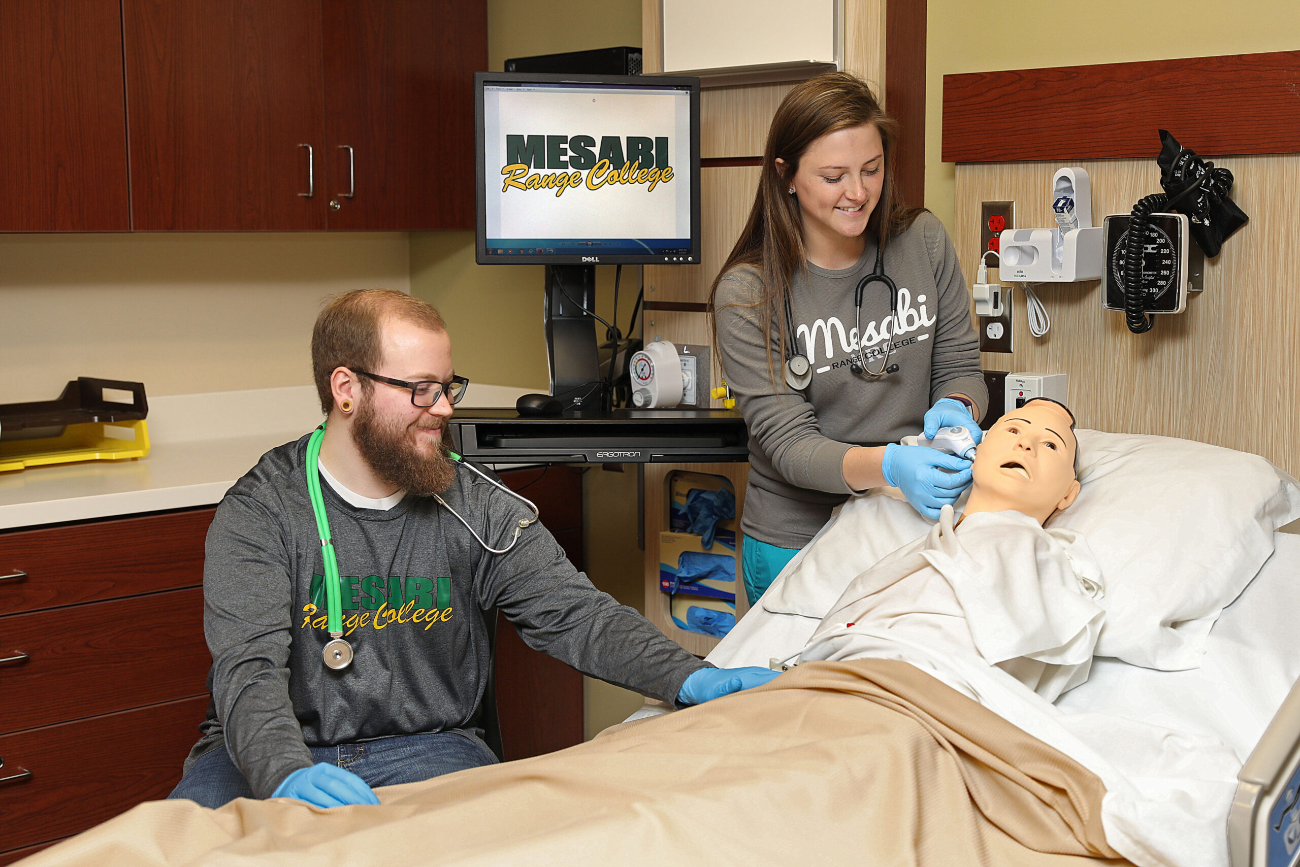 two students practicing on a dummy