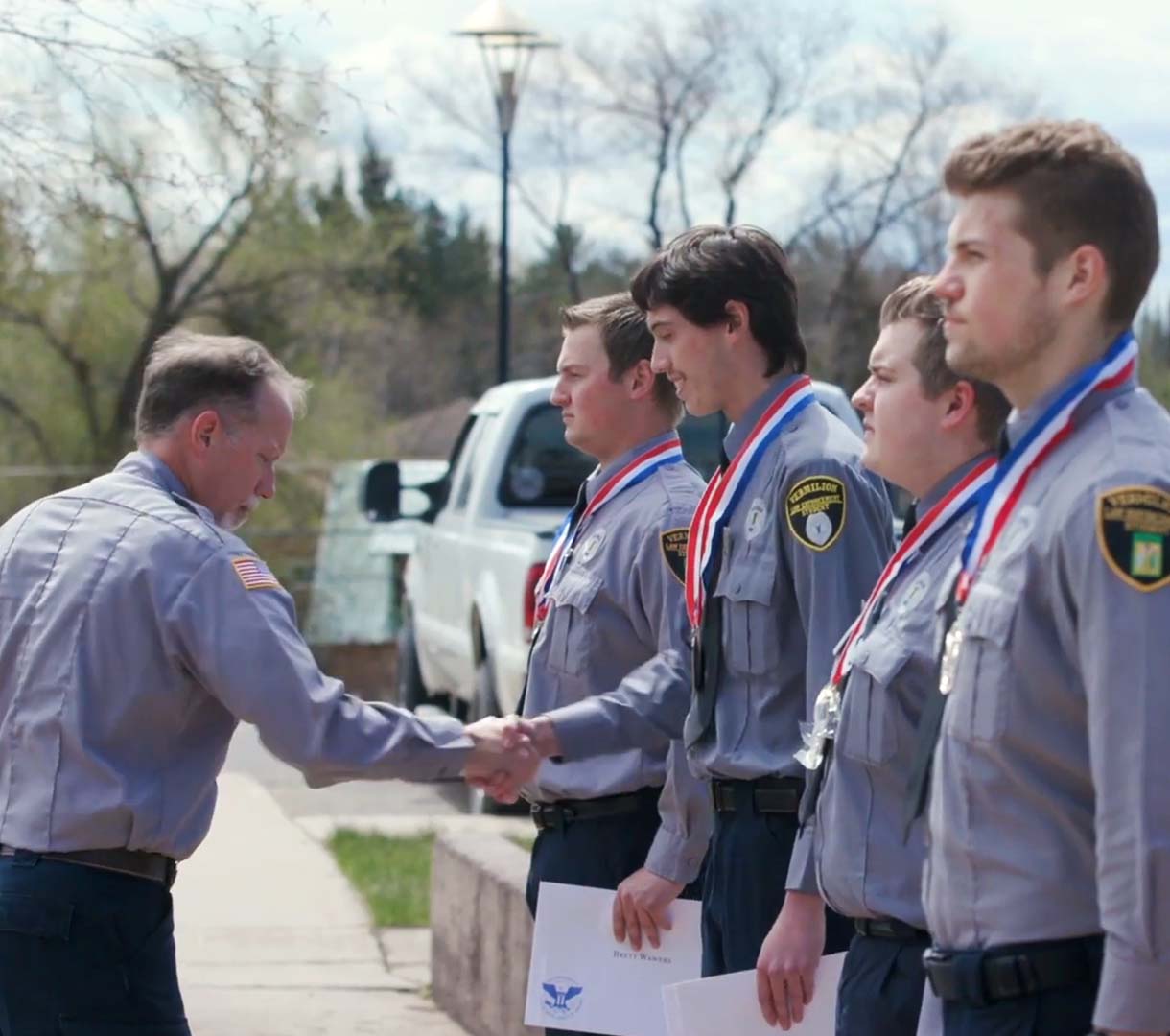 Leader shaking hands of police offers with medals